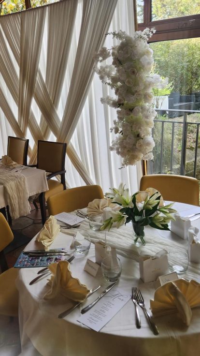Table ronde dressée pour un mariage, voilage blanc et fleurs, à la Villa Paradis'O à Mougins